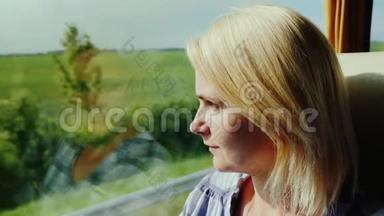 一位年轻女子乘公共汽车旅行。 从窗外看风景如画的风景，很快就经过了